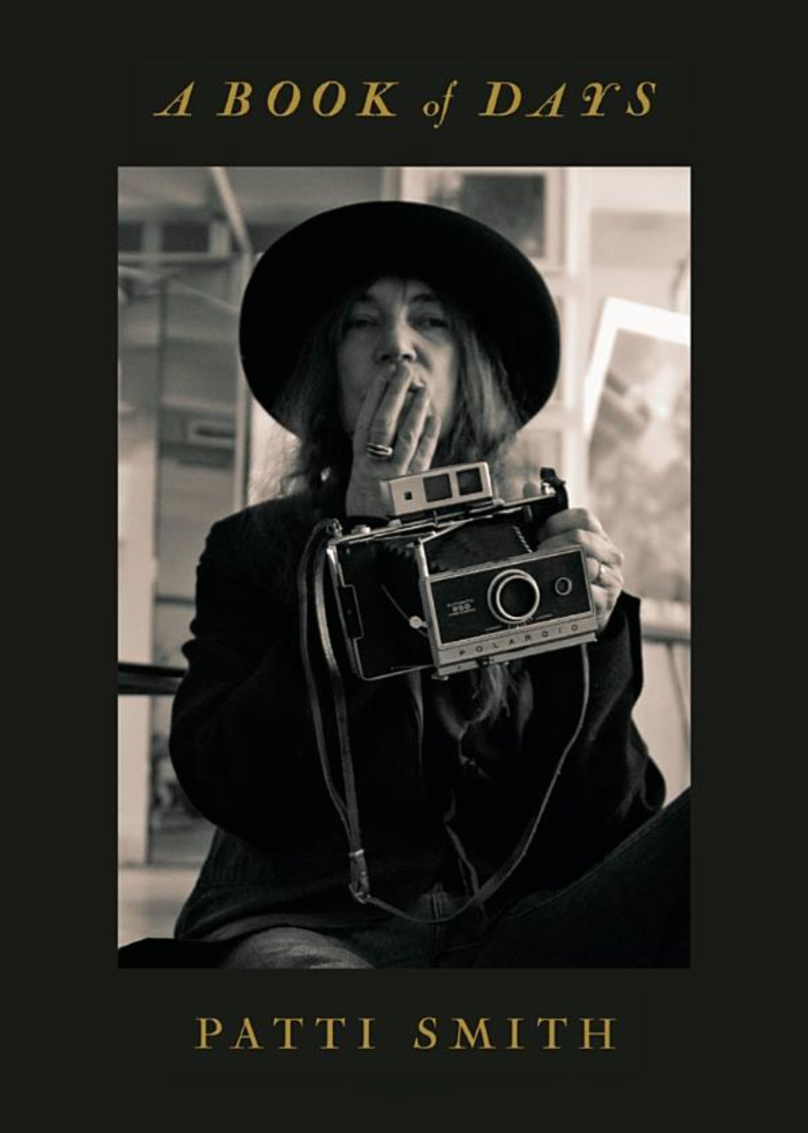 Front cover of Patti Smith’s “A Book Of Days.”

She is seated, her right hand covering her mouth, and her left holding her Polaroid Land 250 camera.