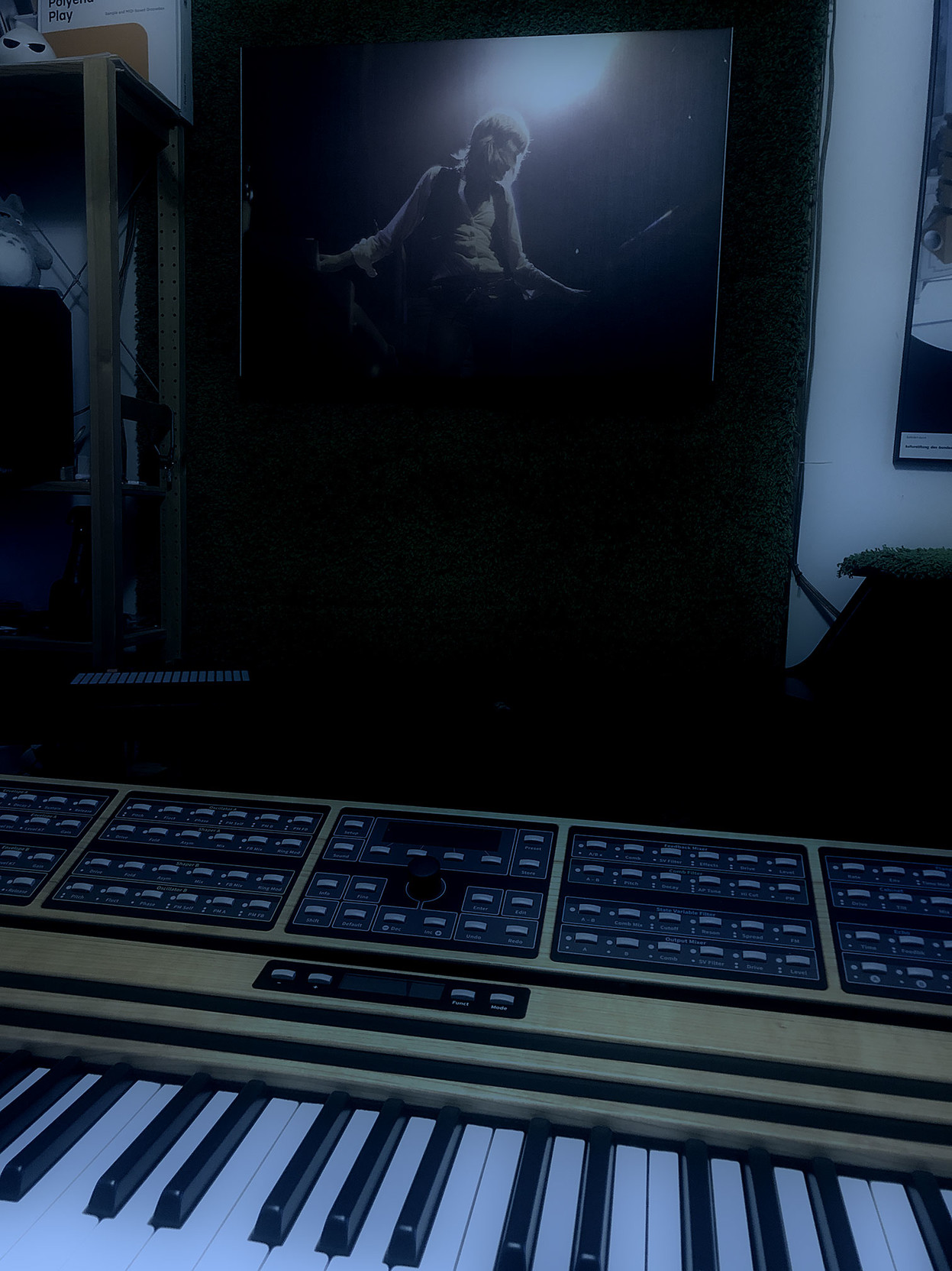 In the foreground, the keyboard and control panel of an exotic C15 synthesizer.

In the background, a canvas print of Keith Emerson playing two Hammond organs at once, with a blaze of light flaring around his head.