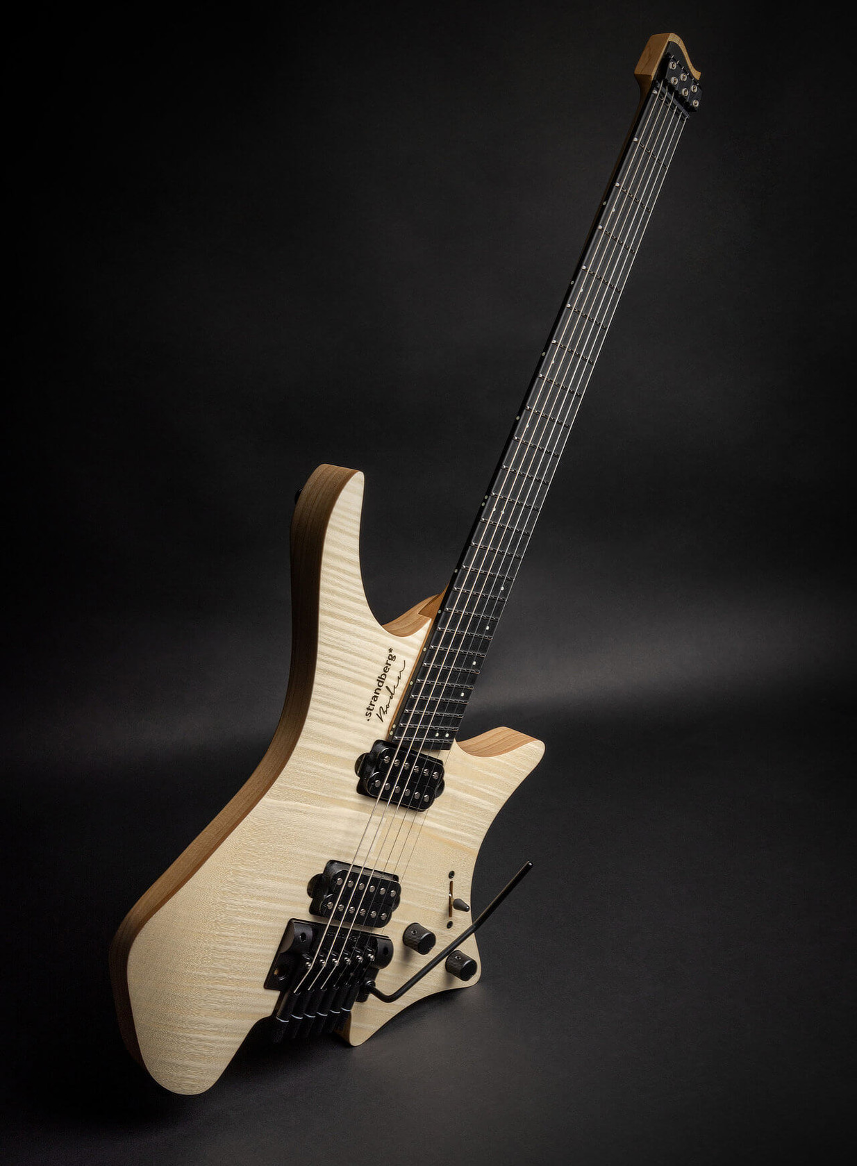 A promo photo of the .strandberg* Prog NX 6 Natural guitar, with a gorgeous pale gold flame maple finish.