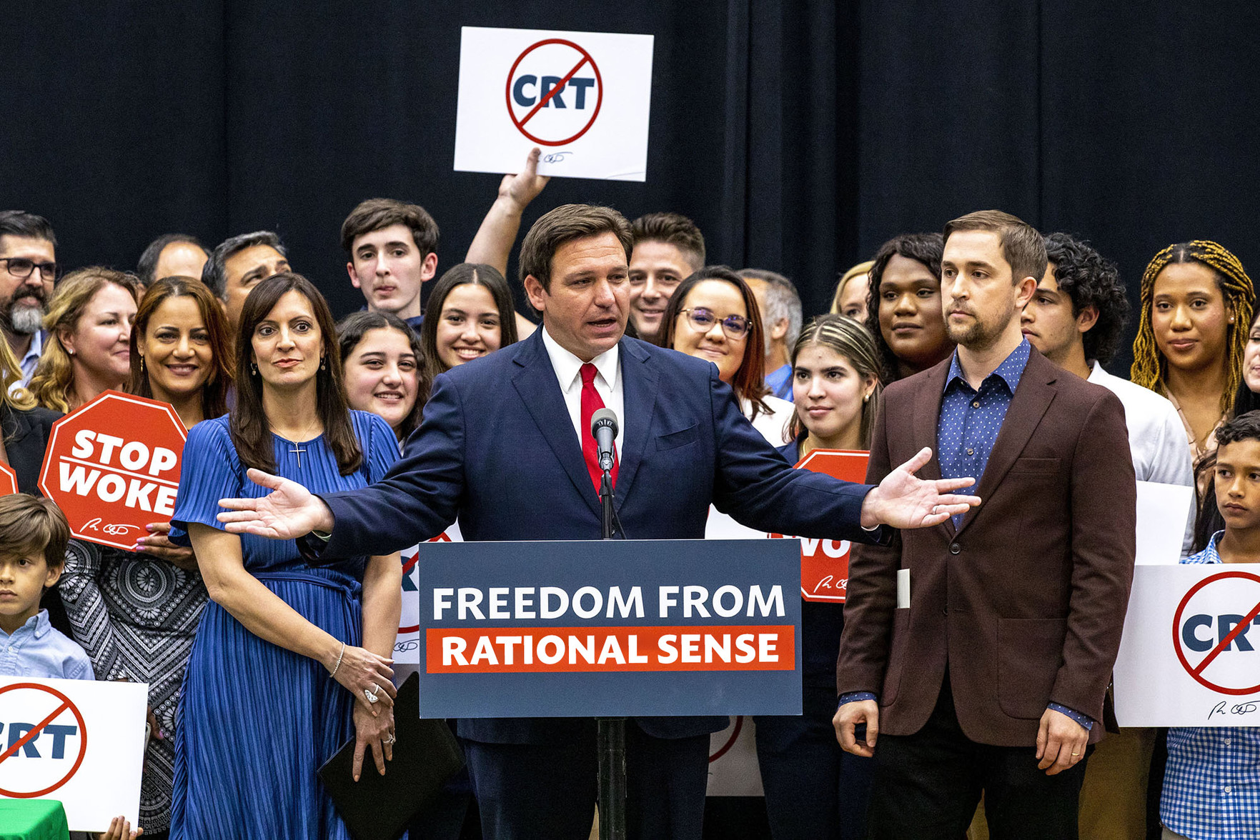 Photo of Ron DeSantis at a podium. I edited the sign to read “Freedom From Rational Sense.”
