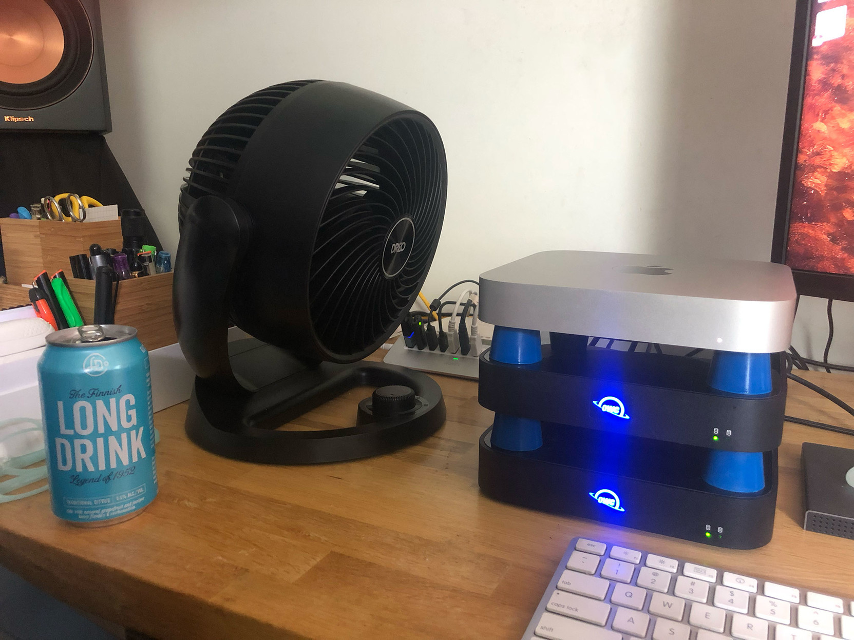 My solution for keeping my Mac cool … two Thunderbolt drive enclosures and my Mac, stacked with blue silicone stoppers that let a desk fan blow air between them. It’s a tower of power!