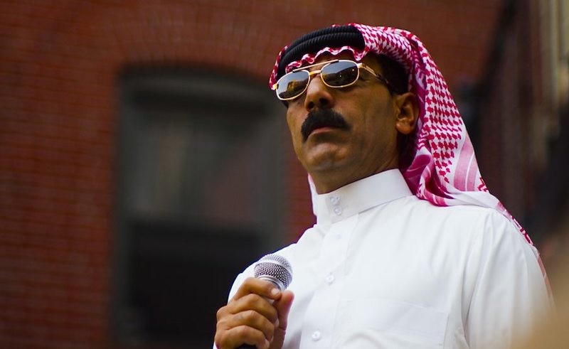 The remarkable Omar Souleyman, styling a natty pair of shades and holding a microphone.