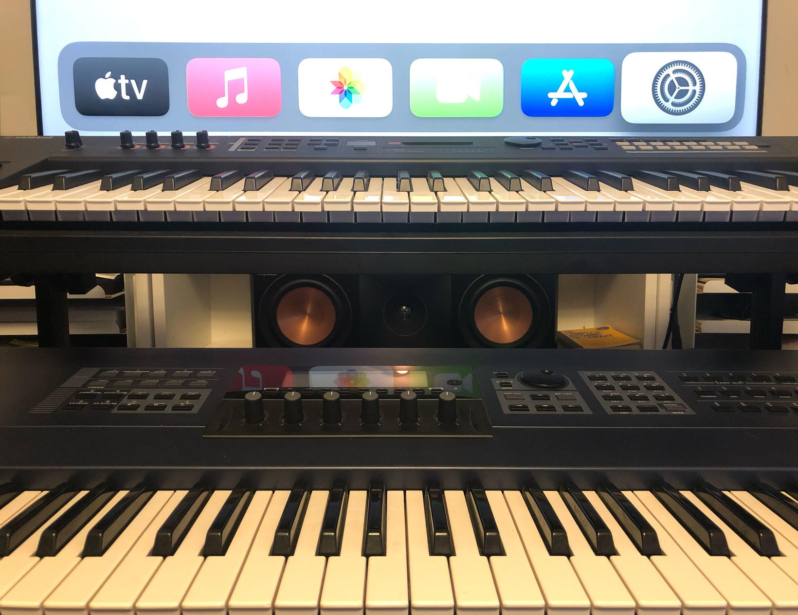 A view of my center surround speaker, aligned between the two front keyboards in the studio, and just under the 4K hero monitor.