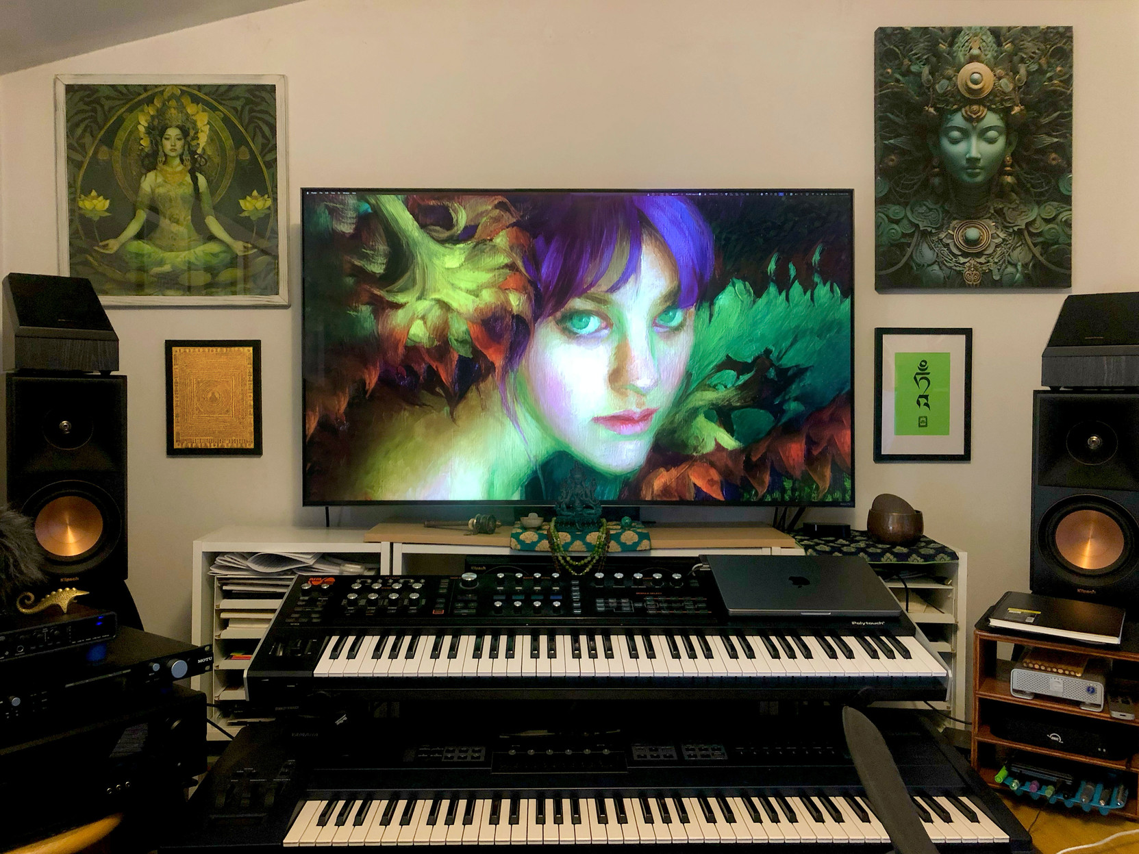 The front of my studio, with various Buddhist and Green Tara images on the wall … and a little Tara statue in the center.

The image on the monitor came up at random, but looks like the artist could have had Tara in mind.

The synths are a Hydrasynth Deluxe on top, with a beloved old Yamaha EX5 down below.