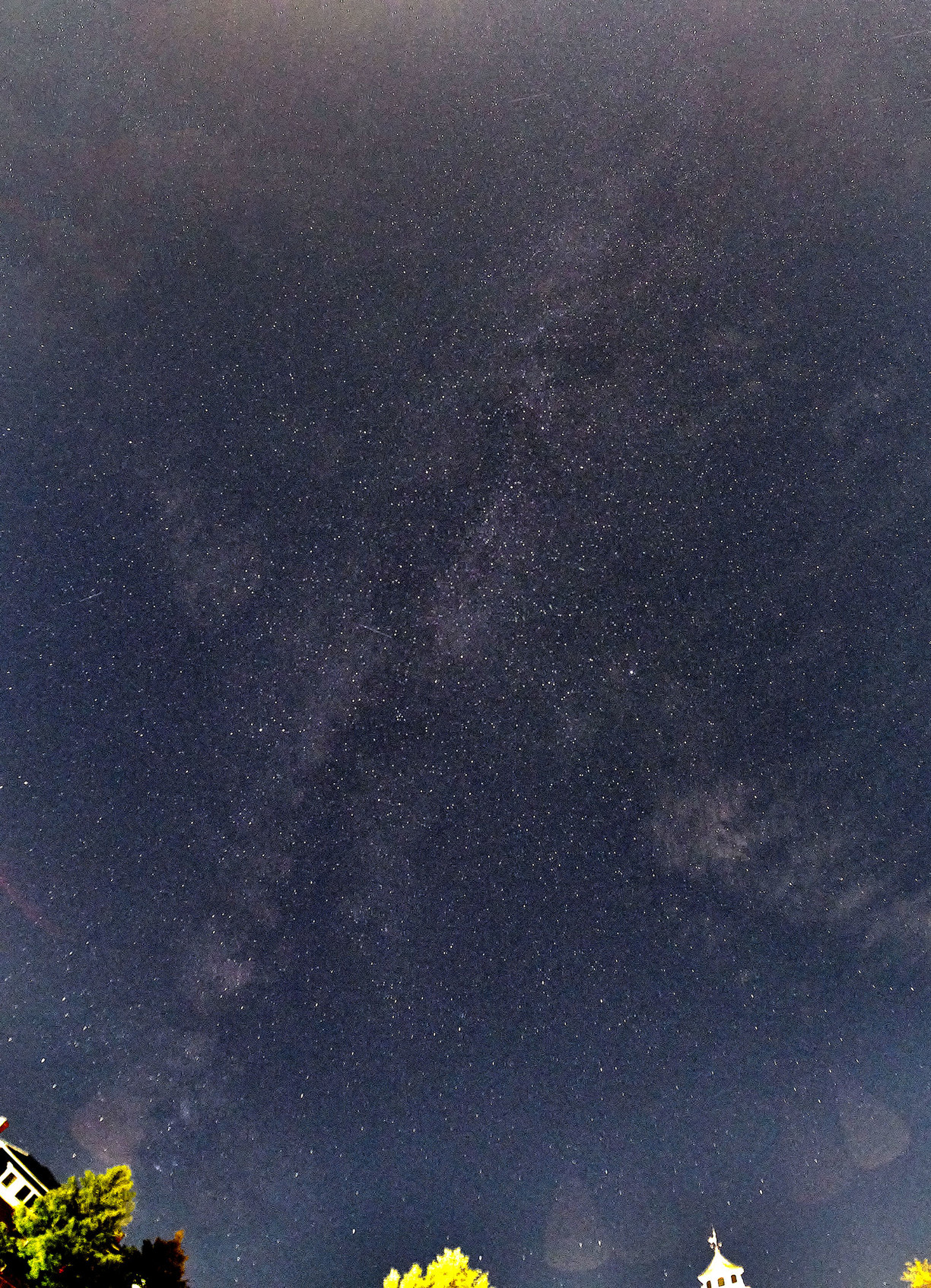 A less-than-satisfactory attempt to photograph the Milky Way from the center of town.

My fisheye lens was pointed straight up into the sky, and this view stretches from the southwest to the northeast horizons. 

The disk of our galaxy can be seen as a diagonal from the lower left to the upper right; there are also a few thin clouds. 