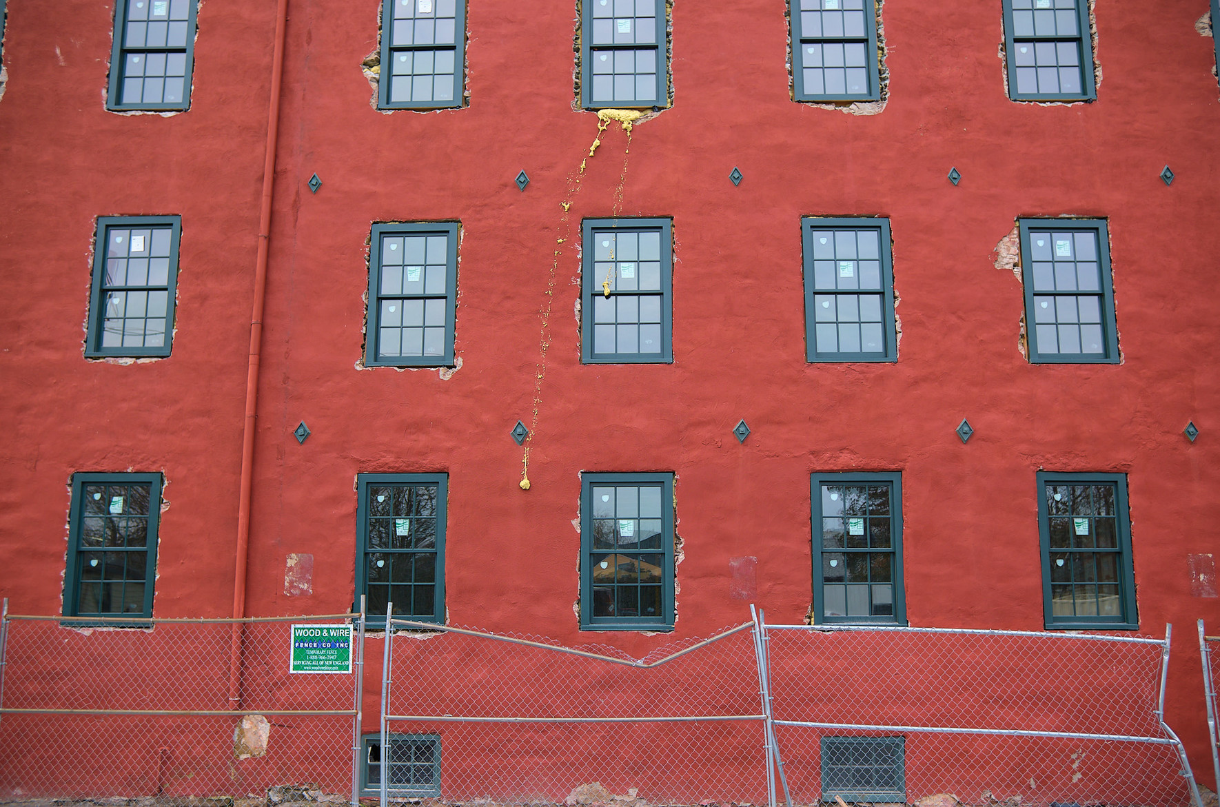 The red facade of a building under renovation.